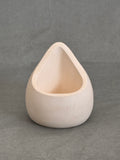 Triangular concrete object on a grey background